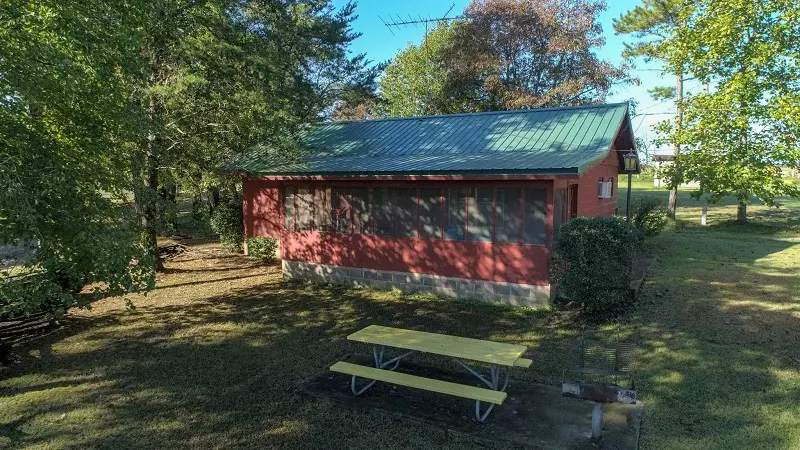 A cabin with a grill and picnic table.